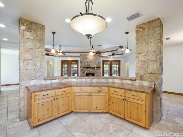 kitchen featuring kitchen peninsula, hanging light fixtures, a tray ceiling, and french doors