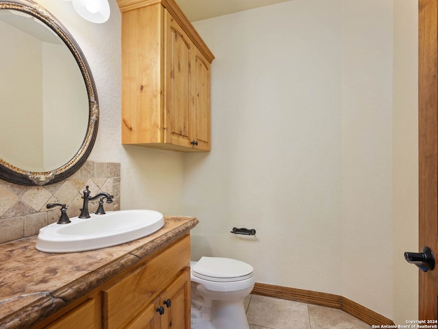 bathroom featuring tasteful backsplash, tile patterned flooring, vanity, and toilet