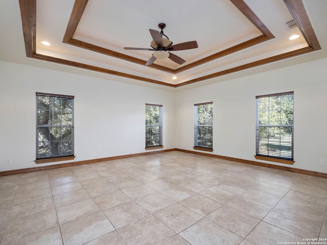 unfurnished room with a tray ceiling, ceiling fan, and ornamental molding