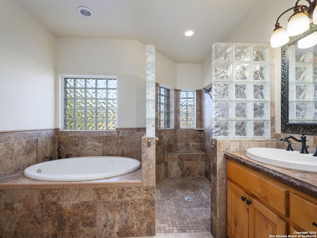 bathroom featuring plenty of natural light, vanity, and independent shower and bath