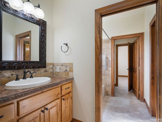 bathroom featuring tile patterned flooring, vanity, and tasteful backsplash