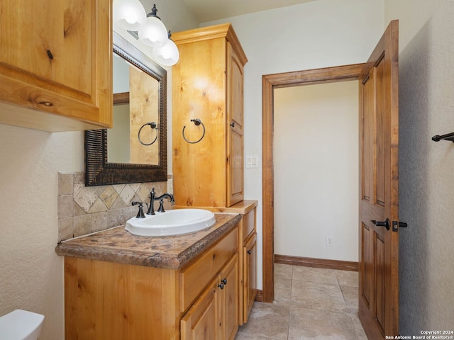 bathroom with tasteful backsplash, tile patterned flooring, vanity, and toilet