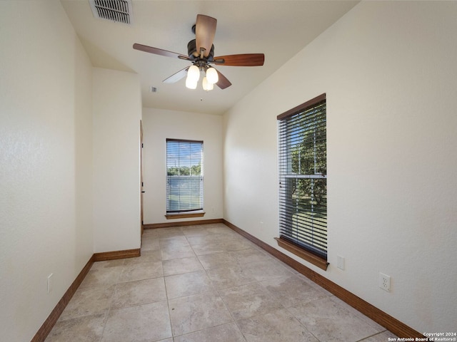 empty room with ceiling fan and light tile patterned flooring