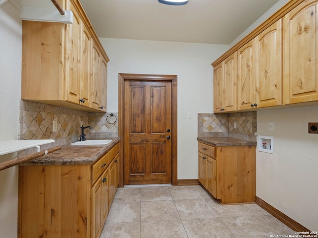 kitchen featuring light tile patterned floors, backsplash, light brown cabinetry, and sink