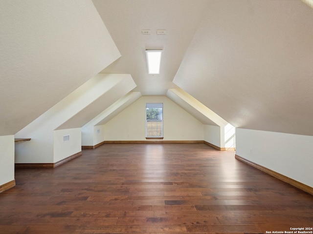 additional living space featuring dark hardwood / wood-style flooring and vaulted ceiling