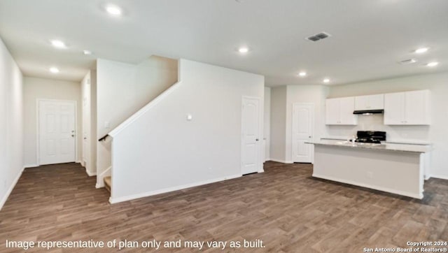 kitchen with black range oven, dark hardwood / wood-style floors, white cabinetry, and a kitchen island with sink