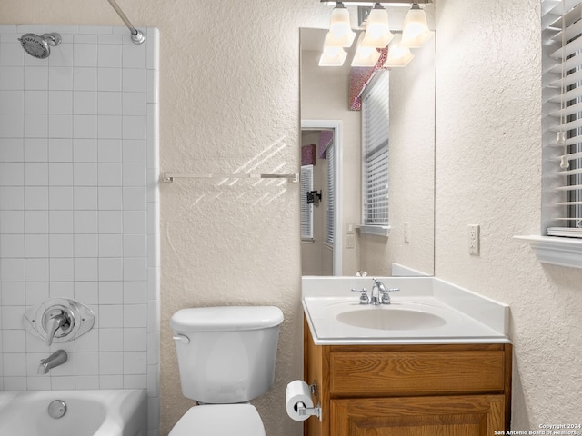 full bathroom featuring vanity, toilet, and tiled shower / bath combo