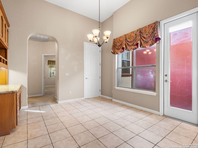 unfurnished dining area featuring light tile patterned floors and a chandelier