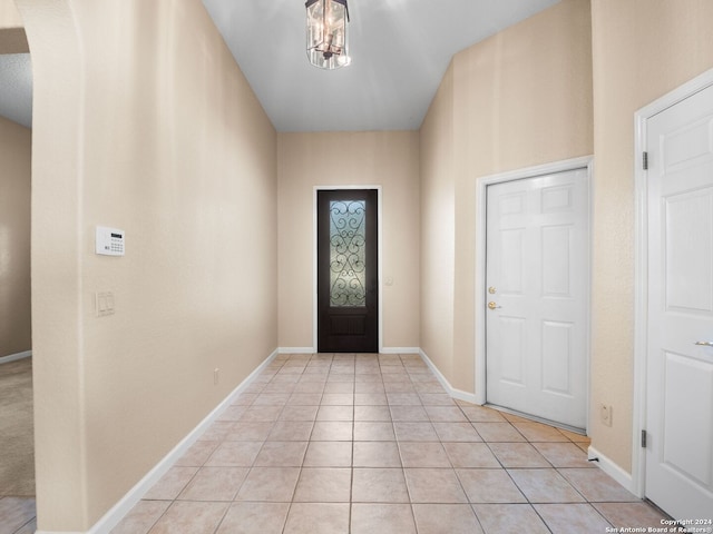 tiled foyer featuring a chandelier