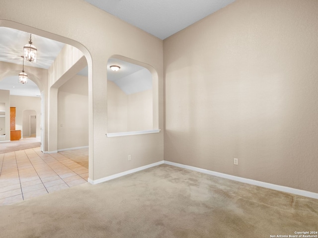 unfurnished room with carpet flooring and a notable chandelier