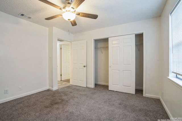 unfurnished bedroom featuring ceiling fan, a closet, carpet, and a textured ceiling