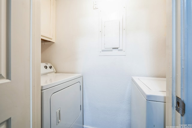 laundry area featuring electric panel, cabinets, and independent washer and dryer