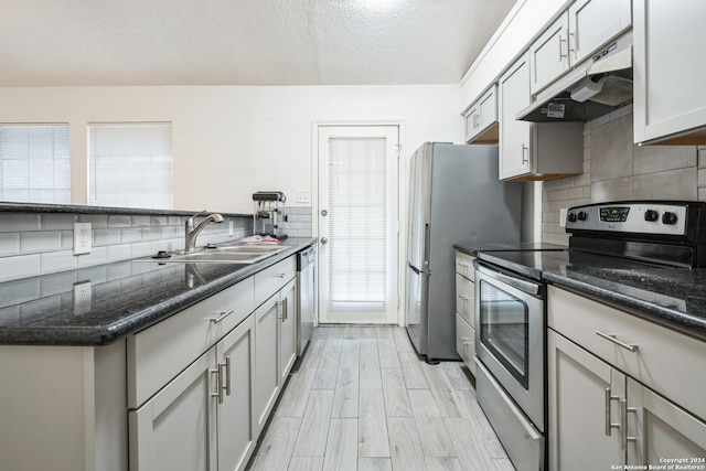 kitchen with dark stone countertops, sink, plenty of natural light, and appliances with stainless steel finishes