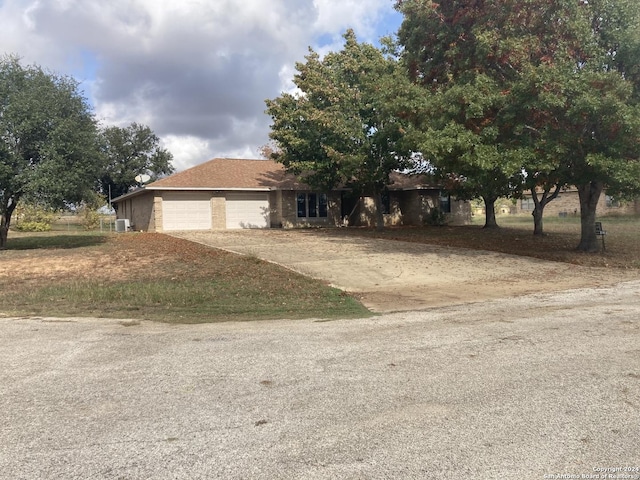 view of front of property featuring central AC and a garage