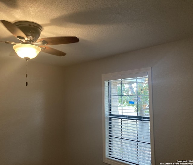 interior details featuring ceiling fan and a textured ceiling