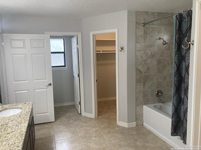 bathroom featuring tile patterned floors, vanity, shower / bath combination with curtain, and a textured ceiling