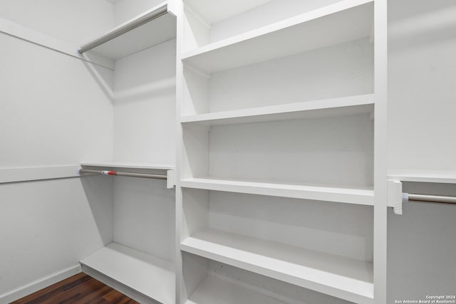 spacious closet featuring dark hardwood / wood-style floors