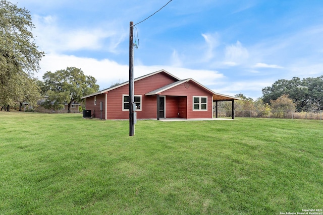 rear view of house with a lawn, central AC, a patio area, and a carport