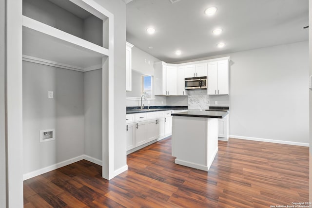 kitchen with dark hardwood / wood-style flooring, a center island, white cabinetry, and sink