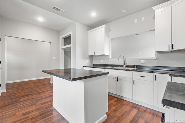 kitchen with white cabinets, a center island, dark hardwood / wood-style flooring, and sink