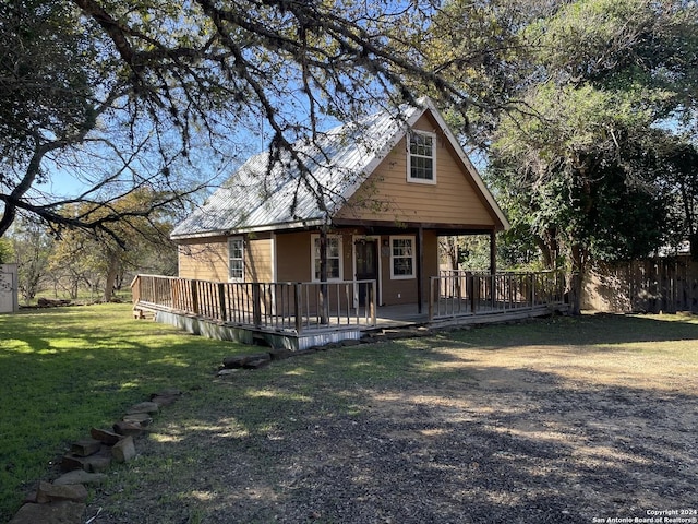 view of front of home featuring a front lawn and a wooden deck