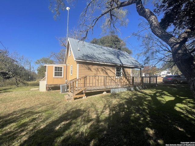 back of property with a wooden deck, a lawn, and central air condition unit