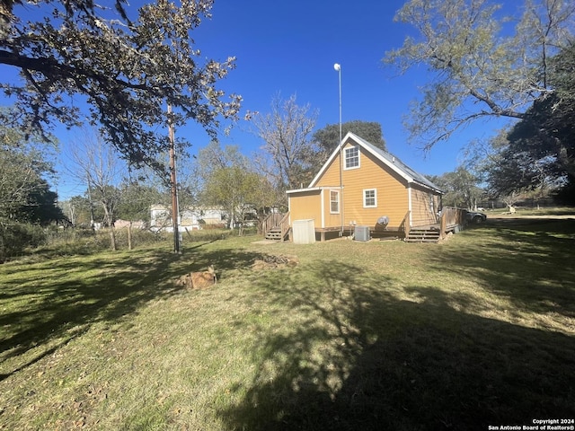 view of side of home featuring a yard and central AC unit