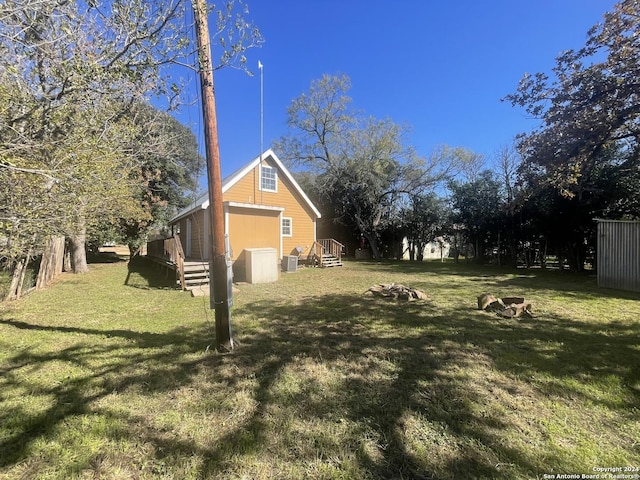 view of yard with central AC unit and a wooden deck