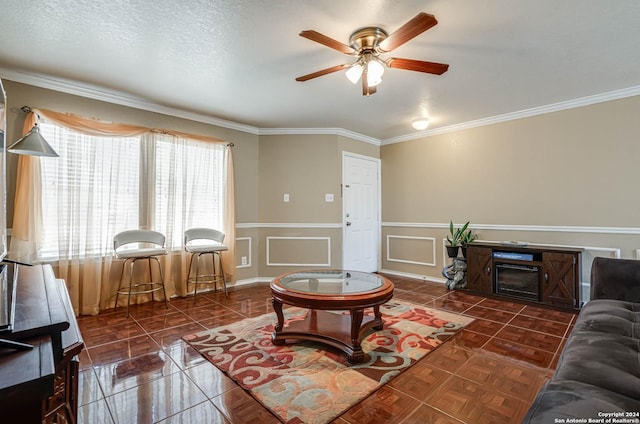 tiled living room featuring a textured ceiling, ceiling fan, and crown molding