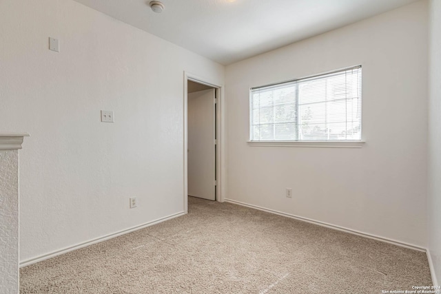 spare room featuring light carpet