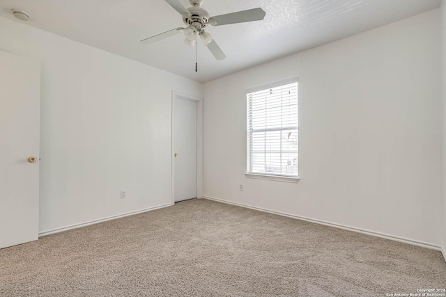 spare room featuring light colored carpet and ceiling fan