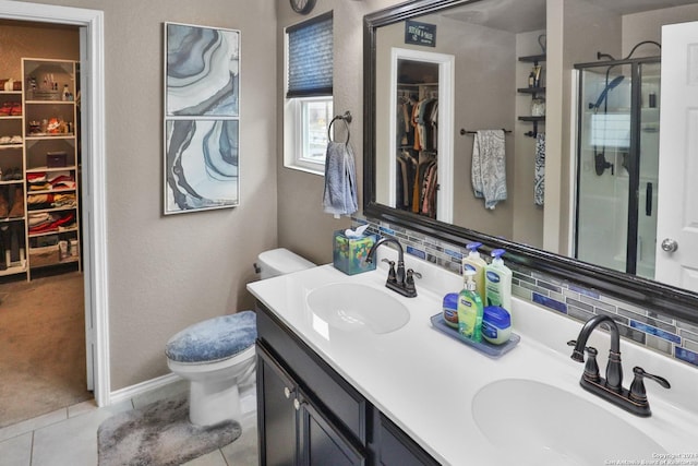 bathroom featuring toilet, decorative backsplash, tile patterned floors, an enclosed shower, and vanity