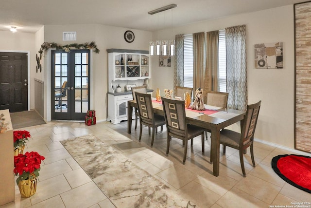 dining room featuring light tile patterned floors and french doors