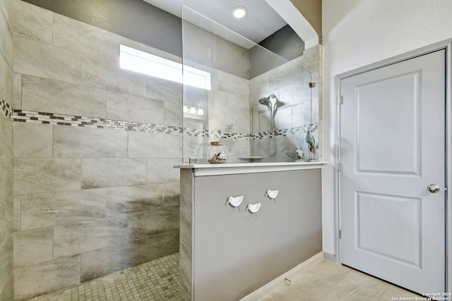 bathroom with a tile shower and tile patterned floors