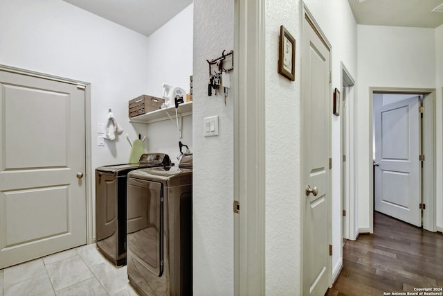 laundry area featuring independent washer and dryer and light hardwood / wood-style flooring