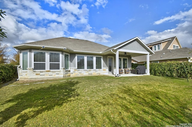 rear view of property featuring a lawn, ceiling fan, and a patio