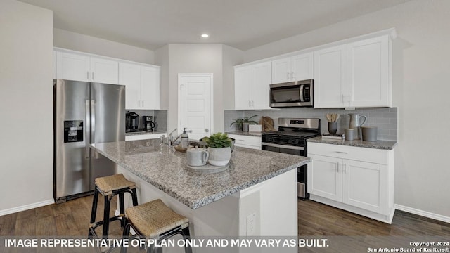 kitchen featuring light stone countertops, appliances with stainless steel finishes, dark wood-type flooring, a center island with sink, and white cabinets