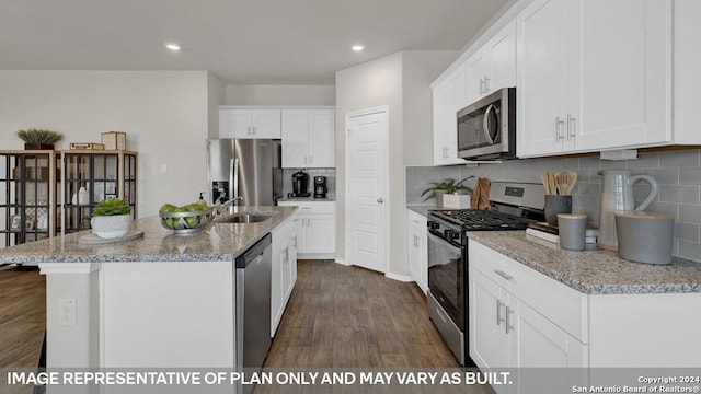 kitchen with white cabinetry, an island with sink, dark hardwood / wood-style floors, and appliances with stainless steel finishes