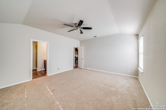 unfurnished bedroom featuring carpet, connected bathroom, ceiling fan, and lofted ceiling