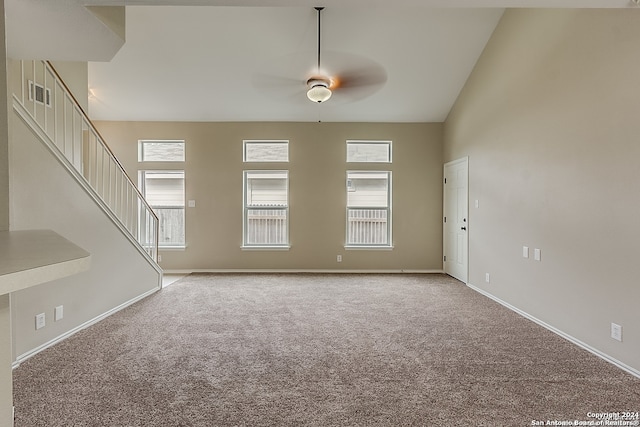 unfurnished living room featuring light carpet, high vaulted ceiling, and ceiling fan