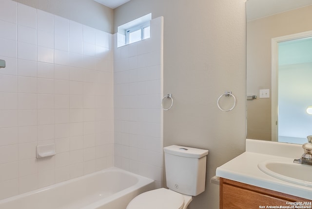 full bathroom with tiled shower / bath, vanity, and toilet