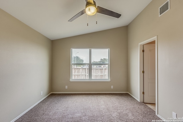 empty room with ceiling fan, light colored carpet, and vaulted ceiling