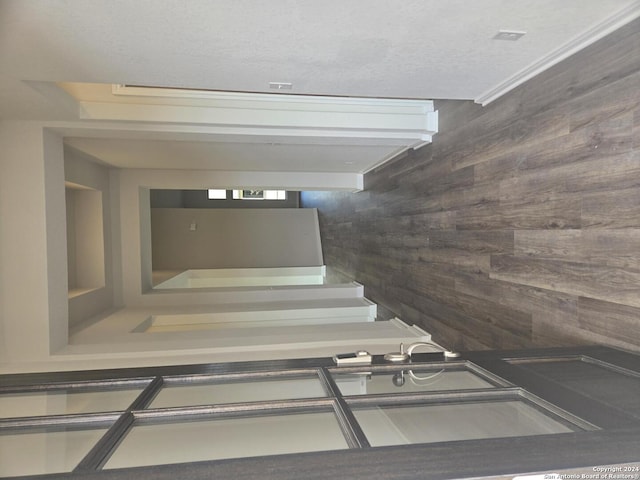 staircase featuring wood walls and a textured ceiling