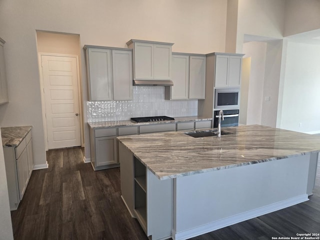 kitchen featuring gray cabinetry, dark wood-type flooring, sink, appliances with stainless steel finishes, and tasteful backsplash