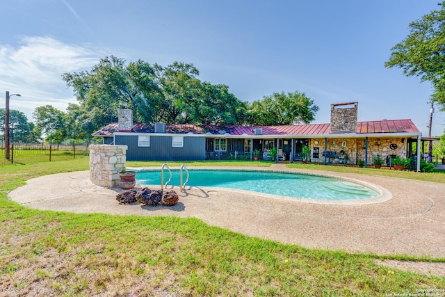 view of swimming pool featuring a lawn