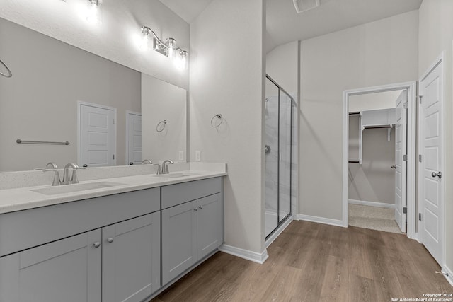 bathroom featuring vanity, hardwood / wood-style flooring, and a shower with door