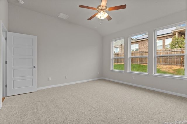 carpeted spare room with ceiling fan and vaulted ceiling