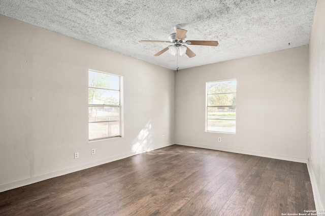 spare room featuring ceiling fan, dark wood-type flooring, a healthy amount of sunlight, and a textured ceiling