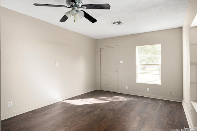 empty room featuring a textured ceiling, ceiling fan, and dark wood-type flooring