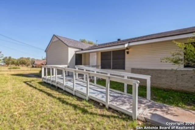 back of property with a lawn and a wooden deck